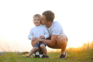 Young father throws up his cute and little son in the fresh air. Father's Day, Father and his son baby boy playing and hugging outdoors. photo