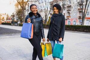 young black women going shopping. African American girls with shopping bags go shopping photo