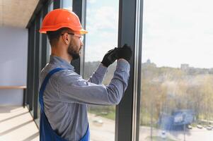 The foreman installs a window frame in the room photo