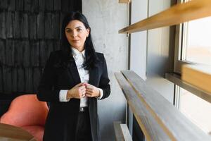 Smiling likable sincere and charming business woman financial executive type portrait inside commercial building. stylish brunette business woman in office photo