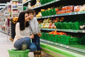 madre y su hijo comprando frutas a un agricultores mercado foto