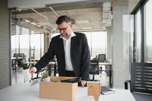 antiguo empleado dejando oficina con el caja lleno de pertenencias foto