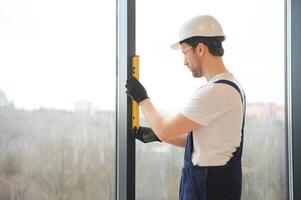 Construction worker installing window in house. photo