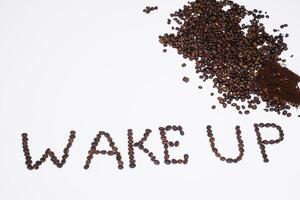 Words wake up from coffee beans isolated on white background photo