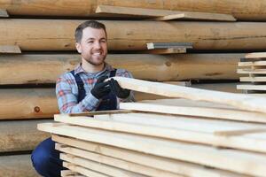 Industrial warehouse of a sawmill, an employee puts his hands on the finished products at the sawmill in the open air. photo