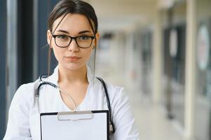 Happy young female doctor wear uniform, white medical coat, stethoscope. Portrait of beautiful female doctor, therapist, nurse. photo