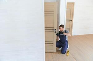 Young man fixing the door in house photo