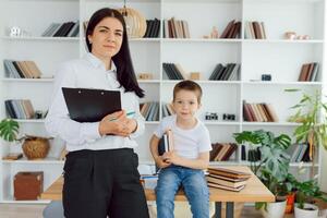 Happy teacher giving smiling girl private lessons after school photo