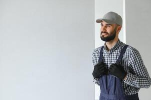 Laughing construction worker on the background of a gray concrete wall. Renovation. place for text photo