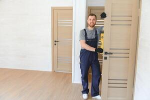 handsome young man installing a door in a new house construction site. photo