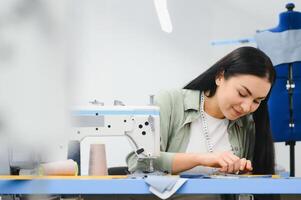 Young woman working as seamstress in clothing factory. photo