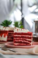 Premium Red Velvet cake and slice include cream, sugar with fork, cup of coffee and pot served on board isolated on napkin side view of cafe food photo