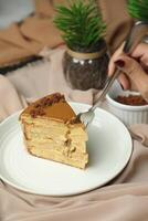 Salted Caramel Blondie cake slice include chocolate cream, sugar with fork, cup of coffee and pot served plate isolated on napkin side view of cafe food photo
