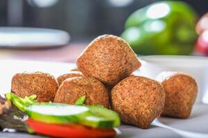 MEAT KIBBEH with salad served in a dish closeup side view on grey background photo