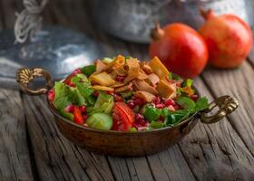 Fatoush served in dish side view on wooden table background photo