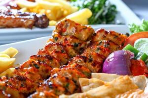 CHICKEN tikka boti KEBAB with salad and fries served in dish close up side view of arab food photo