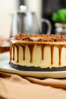Salted Caramel Blondie cake include chocolate cream, sugar with fork, cup of coffee and pot served on board isolated on napkin side view of cafe food photo