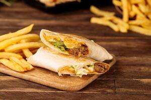 Chicken Kebab shawarma Wraps served in a cutting board isolated on wooden table background side view of fastfood photo