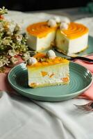 Mango Yogurt Cake slice topping with pistachio fork and flowers served in plate isolated on napkin side view cafe bake food photo