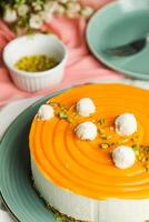 Mango Yogurt Cake topping with pistachio fork and flowers served in plate isolated on napkin side view cafe bake food photo