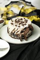 Oreo Cheesecake include chocolate, cream, sugar with fork and flowers served in plate isolated on napkin side view of cafe food photo