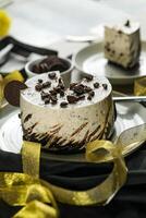 Oreo Cheesecake slice include chocolate, cream, sugar with fork and flowers served in plate isolated on napkin side view of cafe food photo