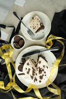 Oreo Cheesecake slice include chocolate, cream, sugar with fork and flowers served in plate isolated on napkin top view of cafe food photo