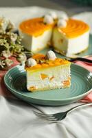 Mango Yogurt Cake slice topping with pistachio fork and flowers served in plate isolated on napkin side view cafe bake food photo