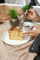 Salted Caramel Blondie cake slice include chocolate cream, sugar with fork, cup of coffee and pot served plate isolated on napkin side view of cafe food photo