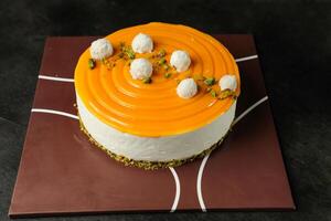 Mango Yogurt Cake topping with pistachio fork and flowers served in plate isolated on napkin side view cafe bake food photo