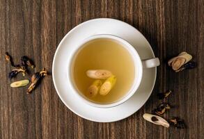 Thai Lemongrass And Ginger Tea Herbal green tea with raw Lemongrass And Ginger. Healthy drinking water, selective focus top on dark wooden background photo