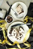 Oreo Cheesecake slice include chocolate, cream, sugar with fork and flowers served in plate isolated on napkin top view of cafe food photo