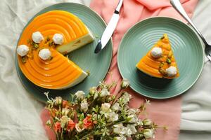 Mango Yogurt Cake slice topping with pistachio fork and flowers served in plate isolated on napkin top view cafe bake food photo