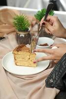 Salted Caramel Blondie cake slice include chocolate cream, sugar with fork, cup of coffee and pot served plate isolated on napkin side view of cafe food photo
