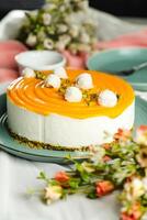Mango Yogurt Cake topping with pistachio fork and flowers served in plate isolated on napkin side view cafe bake food photo