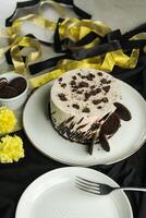 Oreo Cheesecake include chocolate, cream, sugar with fork and flowers served in plate isolated on napkin side view of cafe food photo