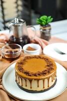 Salted Caramel Blondie cake include chocolate cream, sugar with fork, cup of coffee and pot served on board isolated on napkin side view of cafe food photo