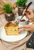 Salted Caramel Blondie cake slice include chocolate cream, sugar with fork, cup of coffee and pot served plate isolated on napkin side view of cafe food photo