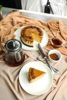Salted Caramel Blondie cake slice include chocolate cream, sugar with fork, cup of coffee and pot served plate isolated on napkin side view of cafe food photo