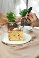 Salted Caramel Blondie cake slice include chocolate cream, sugar with fork, cup of coffee and pot served plate isolated on napkin side view of cafe food photo