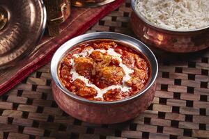 pollo makhani o mantequilla pollo karahi con blanco arroz servido en plato aislado en mesa lado ver de medio este comida foto