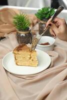 Salted Caramel Blondie cake slice include chocolate cream, sugar with fork, cup of coffee and pot served plate isolated on napkin side view of cafe food photo