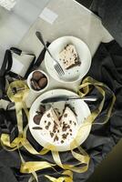 Oreo Cheesecake slice include chocolate, cream, sugar with fork and flowers served in plate isolated on napkin top view of cafe food photo