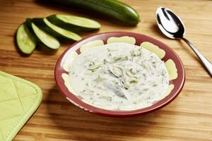 Cucumber yogurt raita served in bowl isolated on table side view of middle east food photo