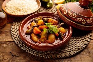 Moroccan tagine with rice served in a dish isolated on wooden background side view photo