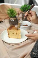 Salted Caramel Blondie cake slice include chocolate cream, sugar with fork, cup of coffee and pot served plate isolated on napkin side view of cafe food photo