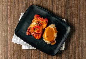 Slices of tasty Tex Mex Grilled Chicken Fajitas served in black tray on dark wood table top view food photo