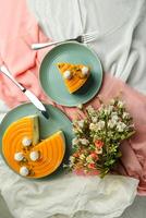 Mango Yogurt Cake slice topping with pistachio fork and flowers served in plate isolated on napkin top view cafe bake food photo