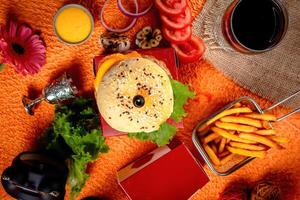 Tongue Twister Beef Naga burger with fries and tomato slice isolated on wooden board side view of american street food photo