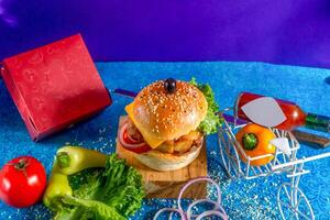 Chicken Cheese Burger with tomato, ketchup and green chilli isolated on wooden board side view of american fast food photo